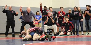 Leaning over with one hand on his thigh, head wrestling coach Jason Thurston put two fingers in the air as senior Austin Bailey scores two points for a takedown in his consolation semifinal match.