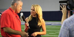 Conducting an interview on the field before the season opening game at the Ford Center at The Star, NFL Network reporter Jane Slater stands with head football coach Chris Burtch.