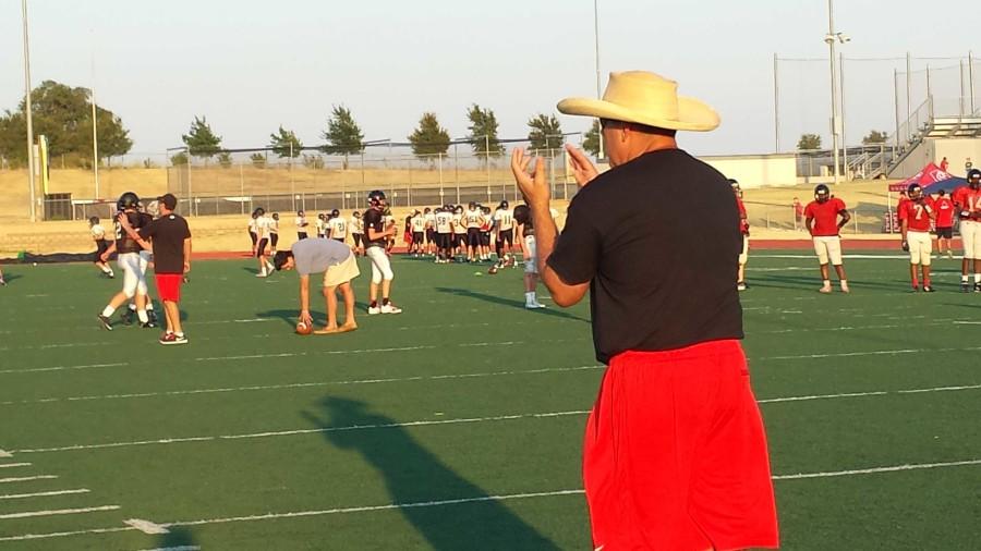 Watching the offense work at the Redhawks Rally practice, head football coach Chris Burtch applauds after a drill. The team has been practicing for weeks with Fridays game against Denison at Toyota Stadium the season opener.