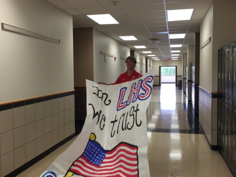 Senior Brandon Steele carries a newly made poster for the upcoming America themed football game. The poster was made by Student Council members and will be displayed on the staircase next week. 