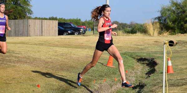 Making her way over a ditch in her sophomore year, Carrie Fish led the way for all varsity girls 5A and under in the Southlake Invitational. Fish finished the course in 19:17:54