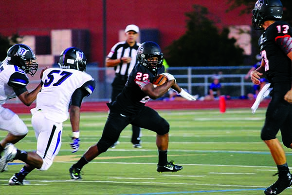 Senior running back Reggie Hubbard carries the ball past the line of scrimmage. 