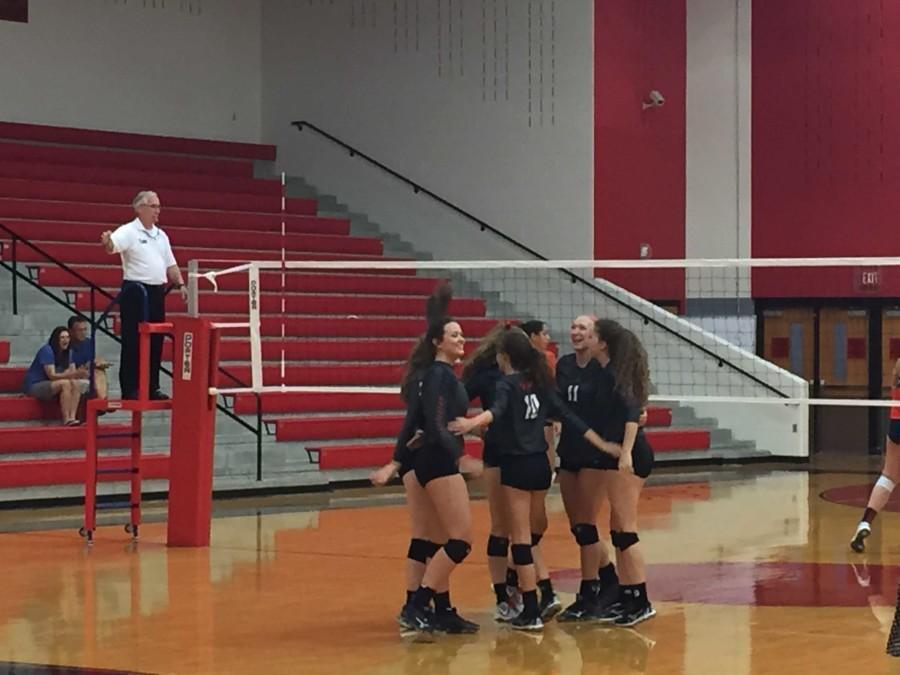 Smiles fill the faces of the volleyball team in their match against Wakeland Friday night. The Redhawks lost 3-1 in the District 9-5A match.