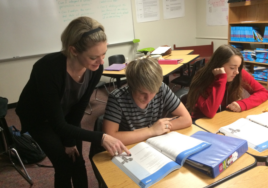 Working with a student in class, English teacher Jennifer Whiffin is also a student herself as she is completing her masters degree at Texas A&M Commerce. 