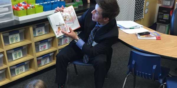 Senior Jay Schlaegel reads a picture book to Taylor Elementary students.