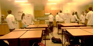With students looking on, teacher Nija Higgins puts out a small grease fire as smoke lingers in the air of the culinary arts room. 