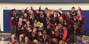 With medals around their necks and the trophy in their hands, the boys' wrestling team poses for a team picture after winning the State Dual Championship.