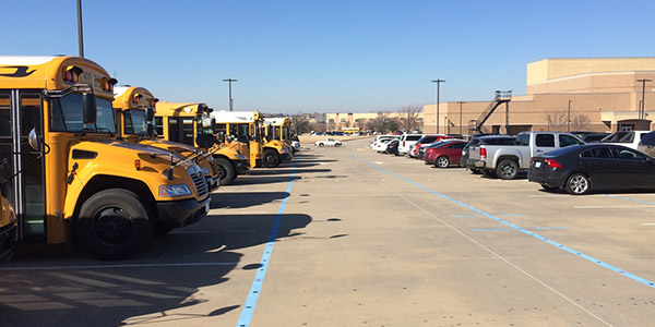 Normally a place for students to park, the band parking lot is filled with school buses and cars for the regional wrestling meet Friday and Saturday. 