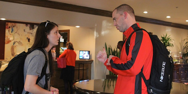 Talking in the hotel lobby, assistant basketball coach Leslie Powell listens to head coach Ross Reedy. 