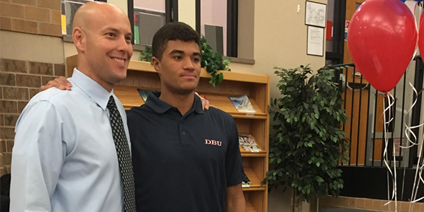 Senior Carter Brown, standing next to head basketball coach Marcus Eckert, signed his Letter of Intent Thursday to play basketball at Dallas Baptist University.