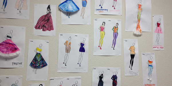 Student fashion designs fill the wall as they design their own work free of guidelines. 