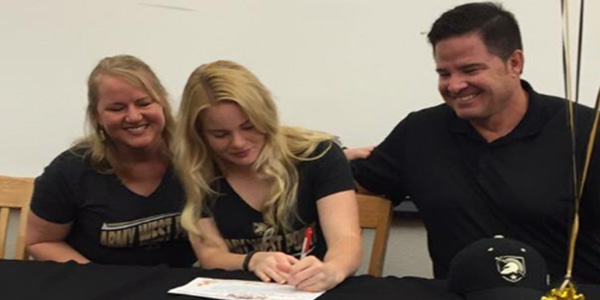 With her parents looking on, Madi Bryant signs her Letter of Intent to continue playing softball at West Point. 