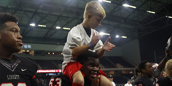 With one of teams younger fans on his shoulders, senior lineman Tyler Hogg celebrates in front of the student section after the teams 50-35 win over Reedy. 