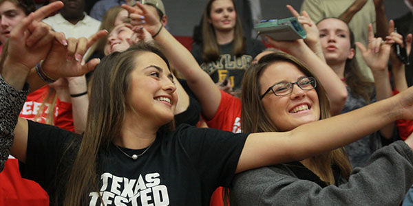 Students interlock their fingers during the performance of the schools fight song at the senior pep rally. 