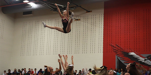 With the help of three others, a cheerleader gets thrown high above the gym floor during a 2016 pep rally.