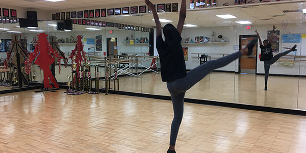 Demonstrating a fan kick, junior Chloe Baines practices her solo choreography.