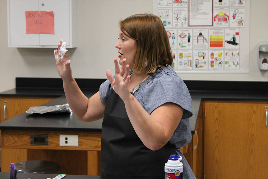 With shaving cream on her right hand, science teacher Lara Russey talks to students on the first day of school after a brief demonstration of what happens when shaving cream and food coloring are added to a piece of paper. 