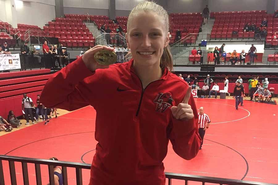 Holding one of her medals, junior Savannah West has four first place finishes this year and has her sight set on a run at state. 