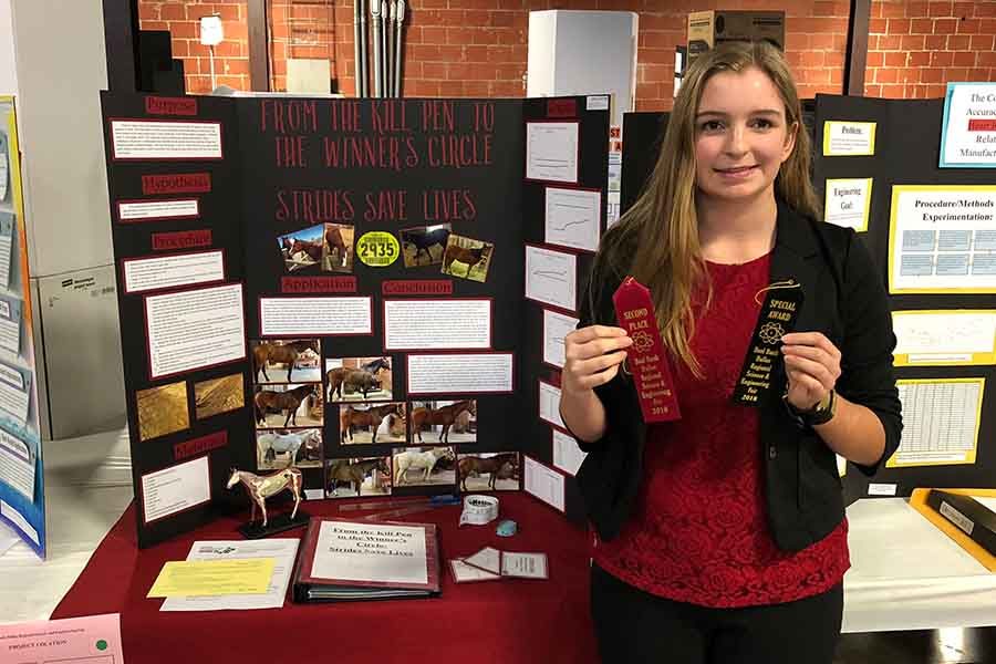Holding her ribbons proudly, freshman Sabrina Wood is awarded first place from the the Dallas County Veterinary Medical Association and second place in Animal Science Computational Biology at the Dallas Regional Science and Engineering Fair.