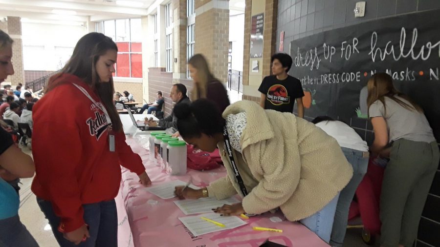 Students line up during lunch to receive their Pink Out T-shirt on Wednesday for the Pink Out game and pep rally on Friday.