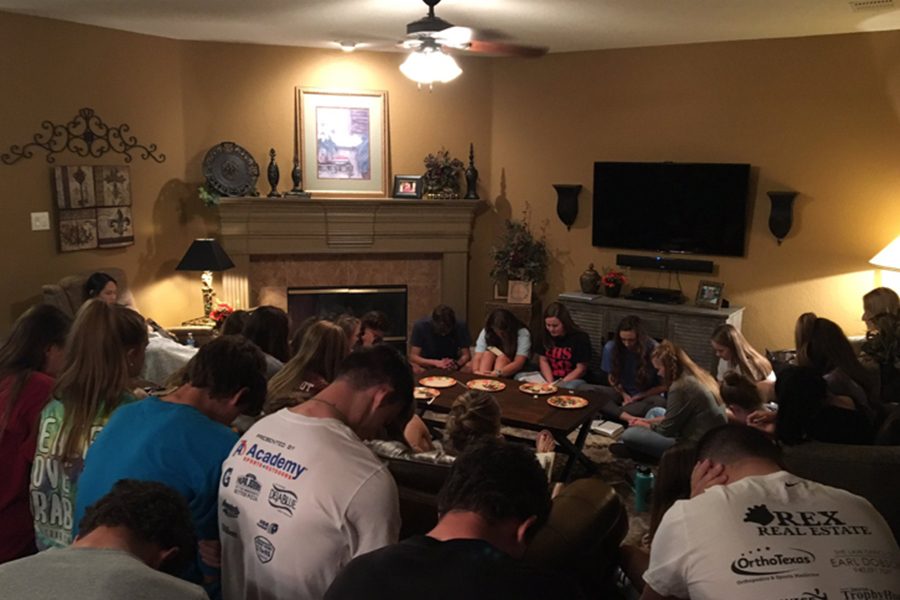 FCA+members+gather+in+prayer+during+a+meeting.