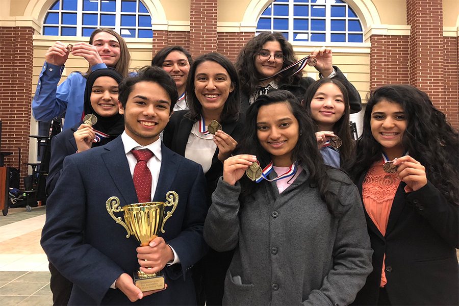 Placing first in every category at Prosper High Schools Fall Invitational, the debate team poses for a victory picture displaying their trophy. Learning from their mistakes, the team will take their win to the next competition in January.