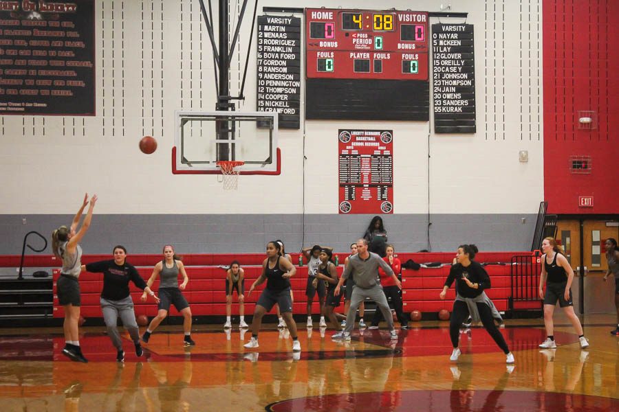 With assistant coach Kristin Lynch closing on her and head coach Ross Reedy also on defense, senior Alyssa Nayar launches a three point shot during a recent practice. The girls team is back in action Thursday with two games in the Allen Hoopfest tournament.