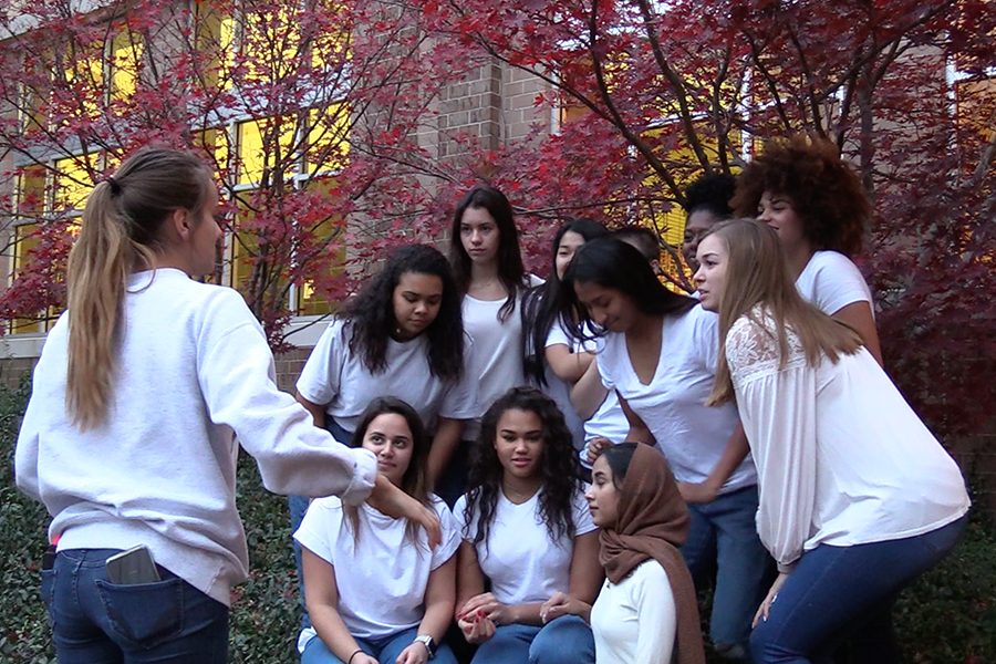 Arranging the girls in a specific order, junior  Amelia Jauregui talks to her diversity models in the courtyard Tuesday after school. 