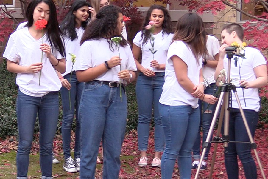 Waiting for direction from junior Amelia Jauregui, the girls chosen for her diversity photoshoot prepare for the next picture in the schools courtyard Tuesday afternoon. 