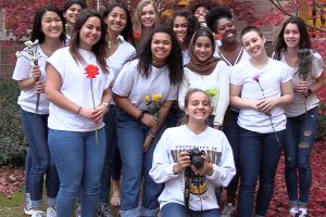 Holding flowers, the 12 girls involved in Amelia Jaureguis photoshoot take a group picture.
