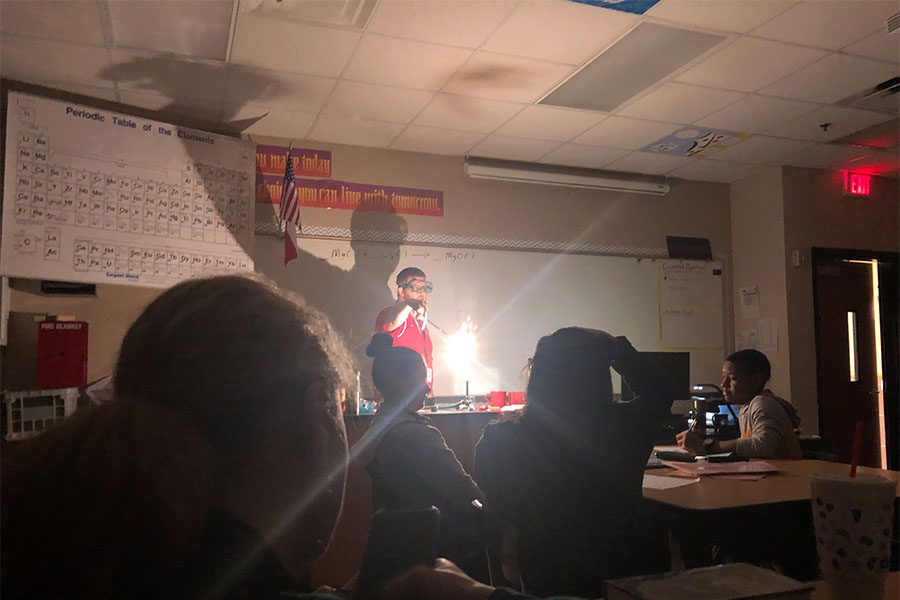 A small fiery explosion lights up the room of chemistry teacher Donald McNeal as he performs a chemical reaction lab to introduce his students to the new unit of chemical reactions. 
