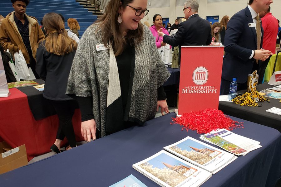 University of Mississippi representative, Mercer Ann Moon, smiles as she waits for students to stop by her informational table during the FISD College Fair. The table includes a variety of informational brochures and flyers advertising the school and its course offerings.