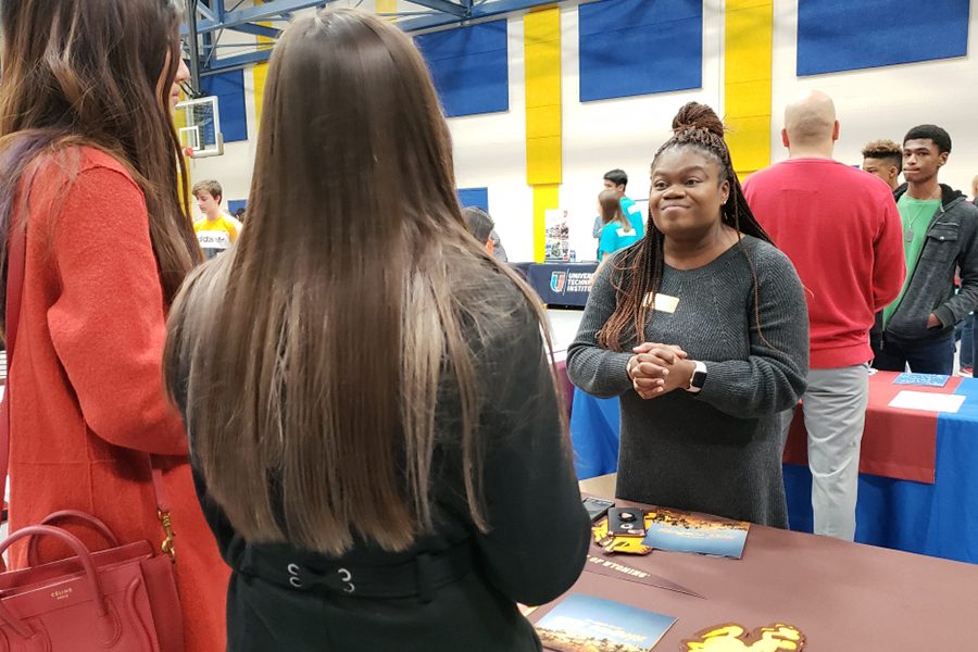During the FISD College Fair, juniors Marley Oldham and Lulia Pan from Heritage High School talk with University of Wyoming representative, Fareett Patrick, about possible choices of major at the University of Wyoming.