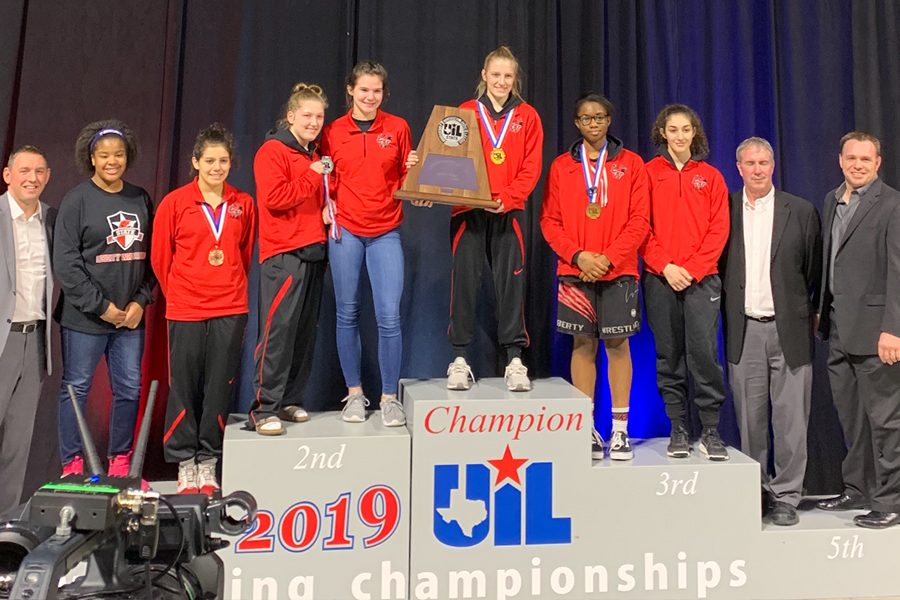 The Redhawk wrestlers pose for a picture alongside their coaches at the UIL State Championship on Friday and Saturday.