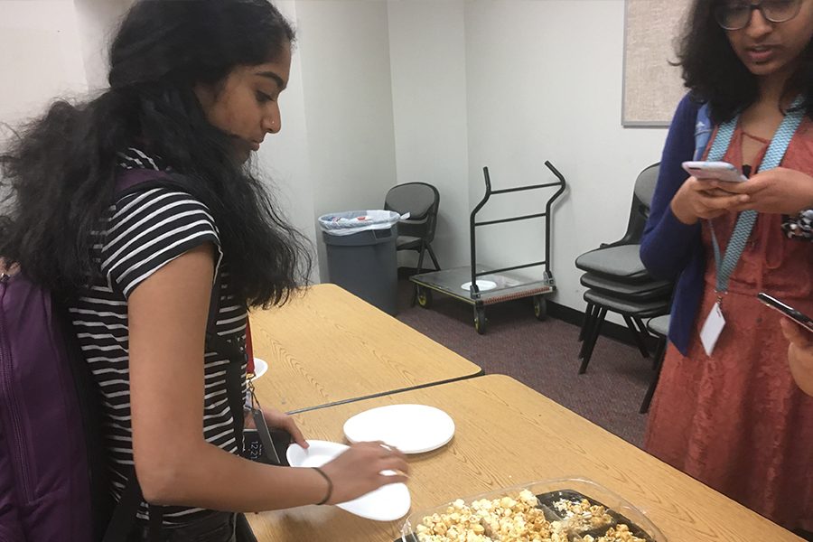 Freshmen Anisya Nair and Lalana Karri enjoy snacks provided after writing notes of gratification towards the custodians of Liberty. 
