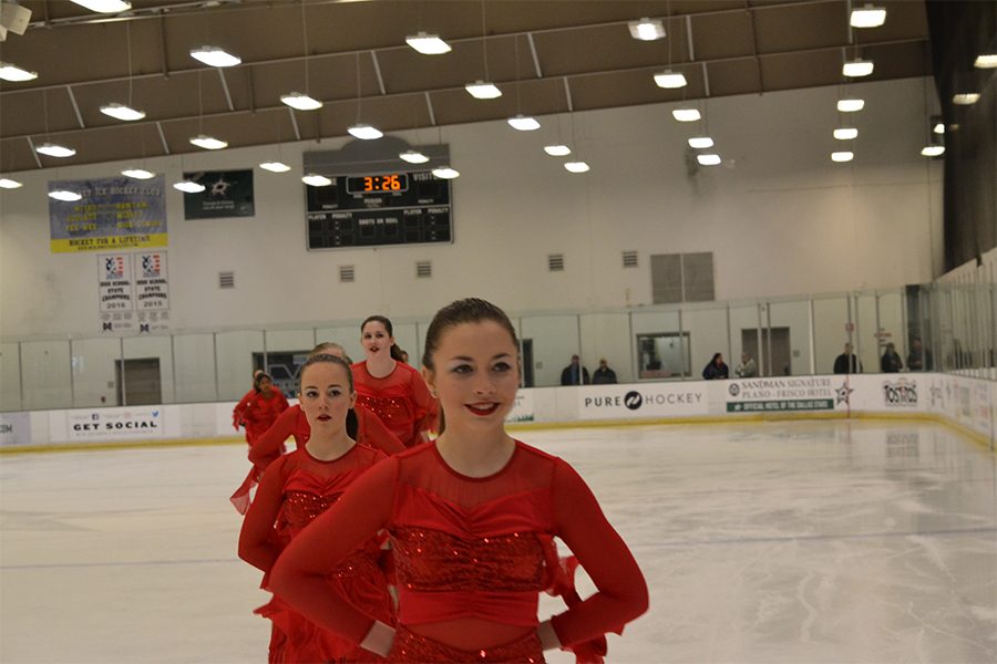 After finishing their routine to their program Fire, Molly Stephenson (9) stands second in line as they skate off the ice. They placed second on this routine. Stephenson started ice skating in third grade. Her interest in skating originated after seeing skaters at ice rinks.