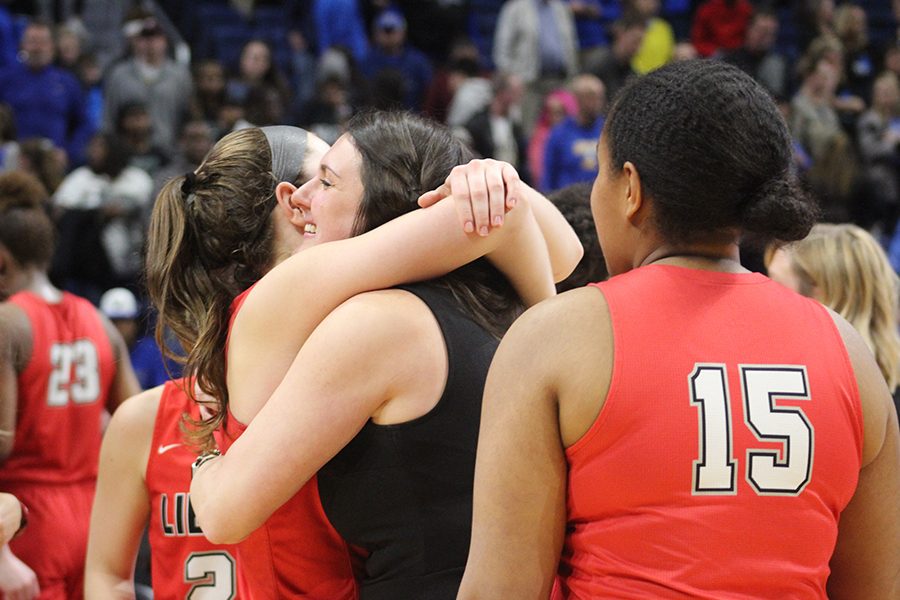 As senior Brittany O'Reilly-Ward (#15) looks on, assistant coach Kristin Lynch hugs senior Kelsey Kurak after the Redhawks secured a place in Saturday's 5A state championship game against Amarillo. The Redhawks got there after beating Kerrville Tivy 34-28 on Thursday, Feb. 28, 2019. 