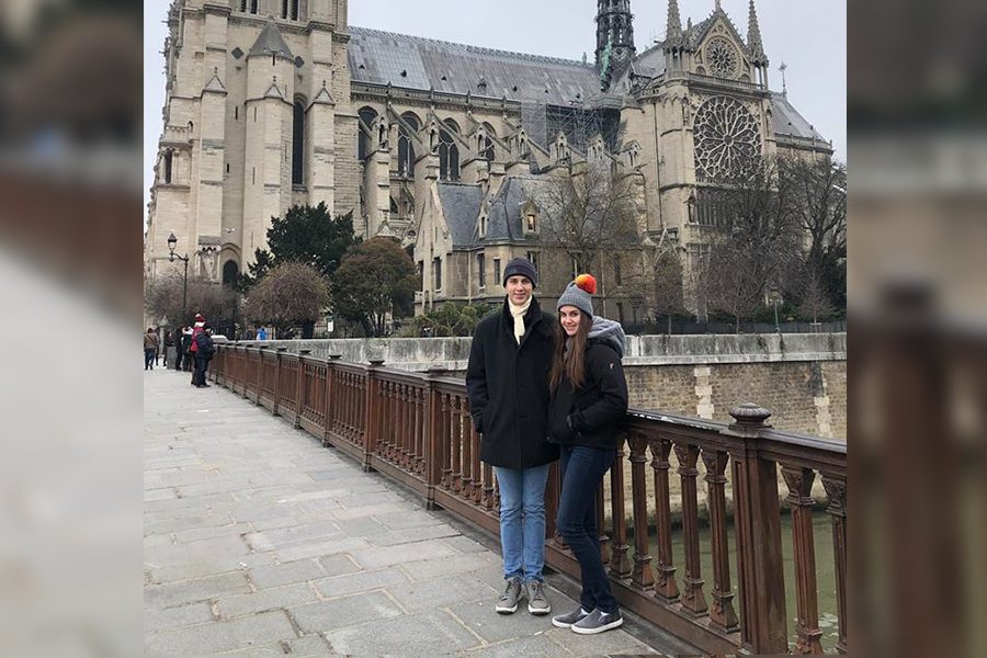 Standing on a bridge over the river Seine, senior Wade Glover and his sister, freshman Sydney Glover, pose for a picture in front of Notre Dame during a family trip to France in December 2018. 