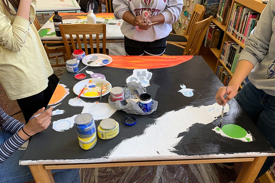 A group of art students consisting of Juniors Fallon Buckner, April Xu, Archana Nagarathinam and Nandasri Talluri begin painting their Library table. The students theme for their table is  outer space, which includes planets, a spaceship, an astronaut and Shrek’s face. 