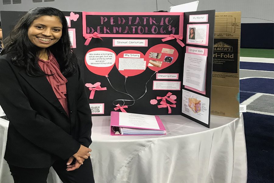At one of her ISM conventions, senior Shenal Christian smiles in confidence as her hair has 100% recovered. She hopes to pursue a career in pediatric dermatology in the future to help provide support for children who going through similar conditions to what she has experienced.