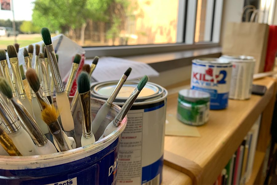 Sitting on the windowsill are various supply for the students to use while they paint the library
tables, including brushes, paints and tape. The various sized brushes allow the art students to
design their tables with precise or large details.