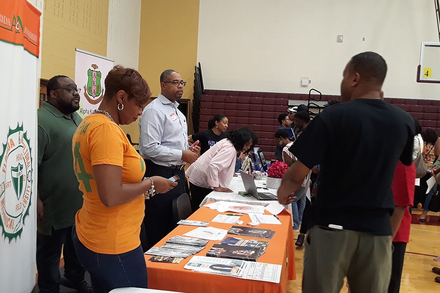 A parent talks with college representatives at the HBCU College Fair and Scholarship Informational Night.

