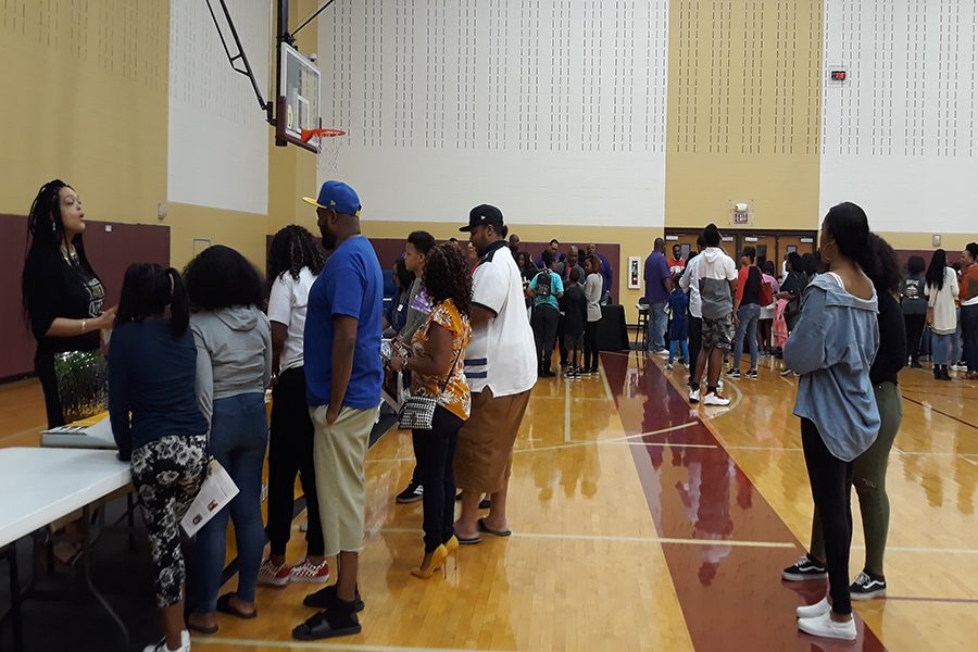 Attendees of the HBCU College Fair and Scholarship Informational Night line up to receive information from their desired colleges and universities. 
