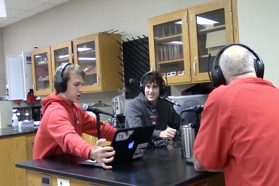 Recording their podcast, freshman Owen Wise, Joseph Hancock, and Ford Shippy interview assistant football coach Larry Swinnea in biology teacher Chris Hams room.