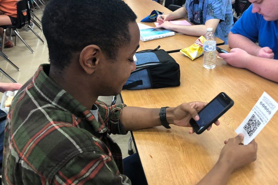 Senior Joreal Watts submitting a song request for homecoming. Students can suggest songs to the DJ via the QR code handout.