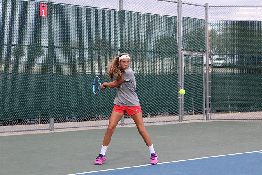 Freshman Mila Dopson winds up to hit the ball during a match. The team headed to Prosper for the Prosper Tournament where they were awarded four medals.