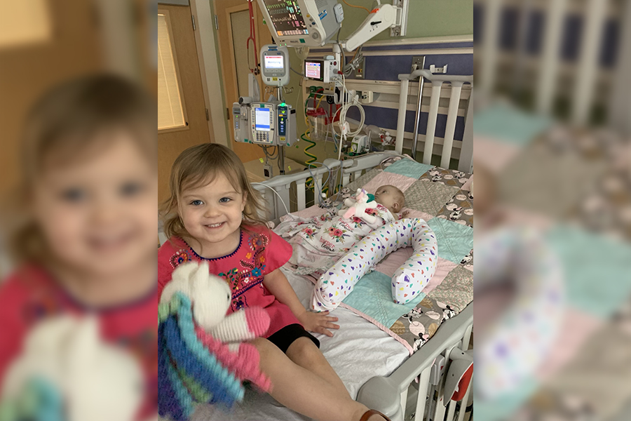 3-year-old Payden smiles for a picture with her sister, baby Harper, in the hospital.