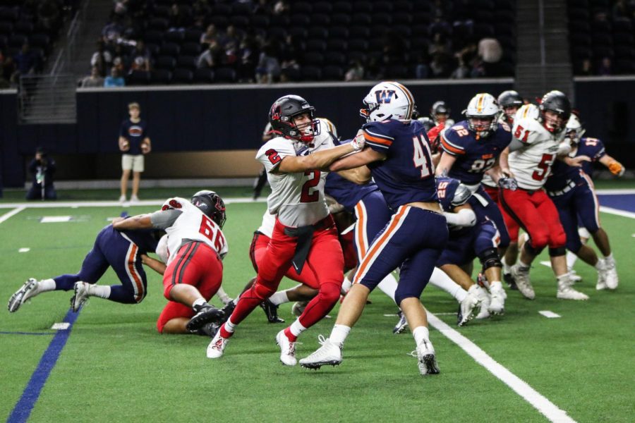 Connor Hulstein fights off the wolverines during a play against Wakeland.