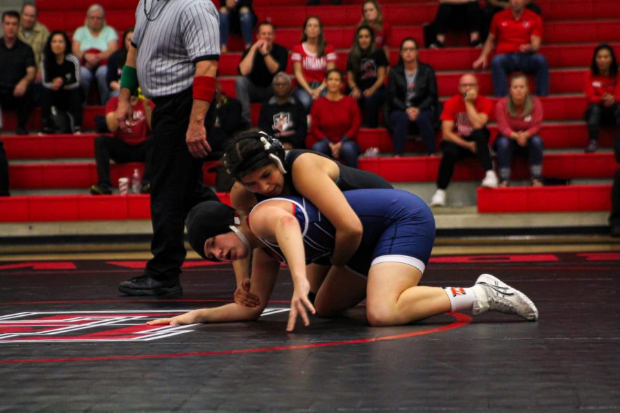 Looking for a pin, senior Karina Quiros works her moves against her opponent from North West High School. For Senior Night, Quiros hopes to keep her district winning streak alive and excited to honor the seniors at their last home dual at 6:00 p.m. with Wakeland and Lebanon Trail. 