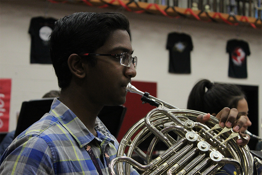 Sophomore Aravind Dharmalingam practices his French horn in band class on January 10th. 